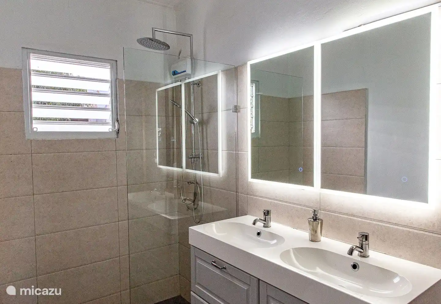 The spacious and modern master bathroom has an extra mirror, hair dryer, first aid kit and shower with hot water.