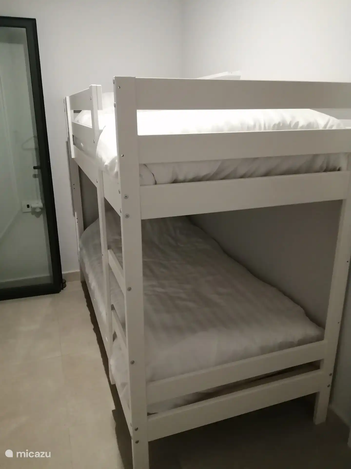 Dormitorio 2 con litera con ropa de cama y armarios de almacenamiento