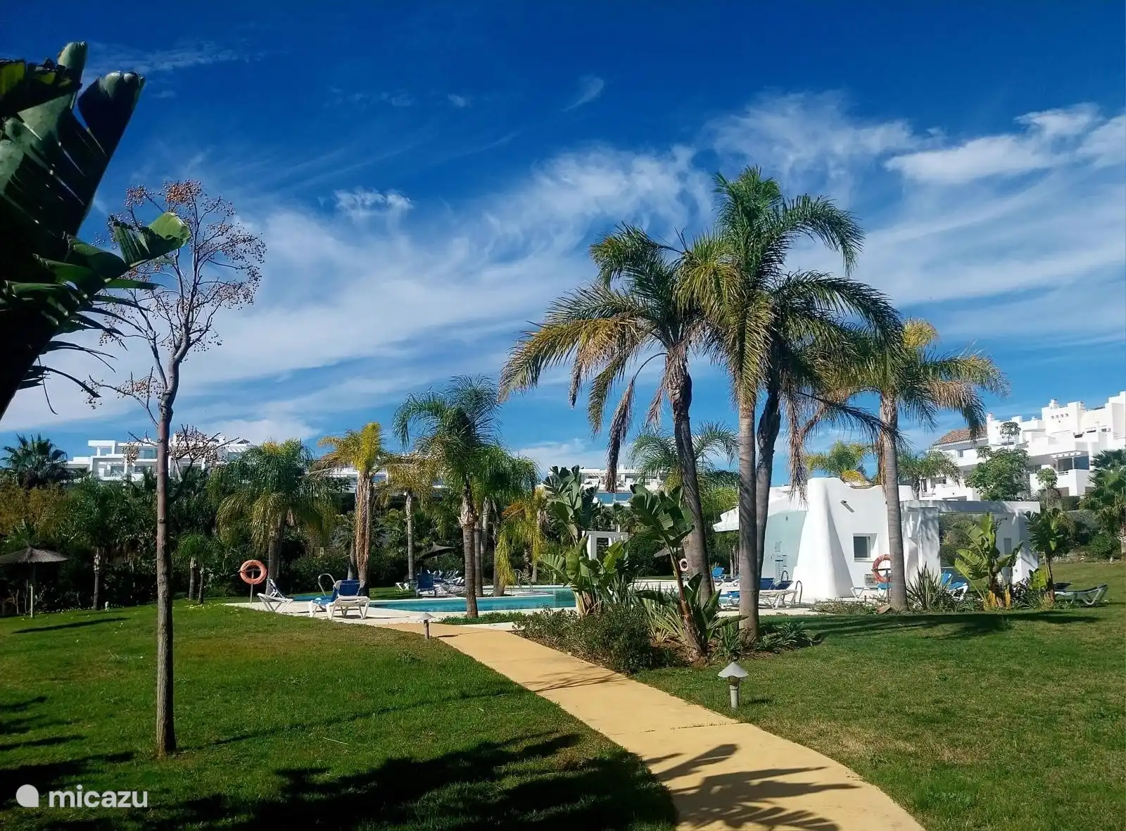 Swimmingpools inmitten von Palmengärten sind zu Fuß erreichbar.