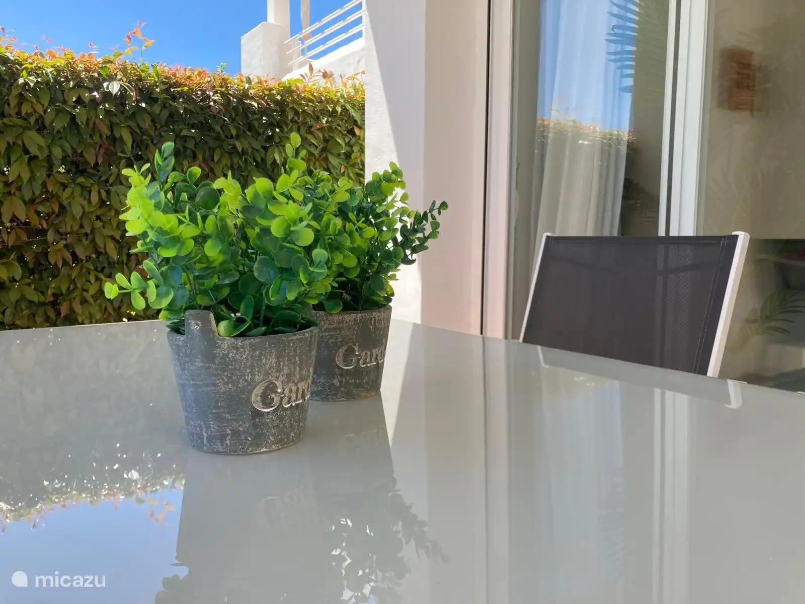 Schöner Gartentisch und Stühle mit Sitzkissen.