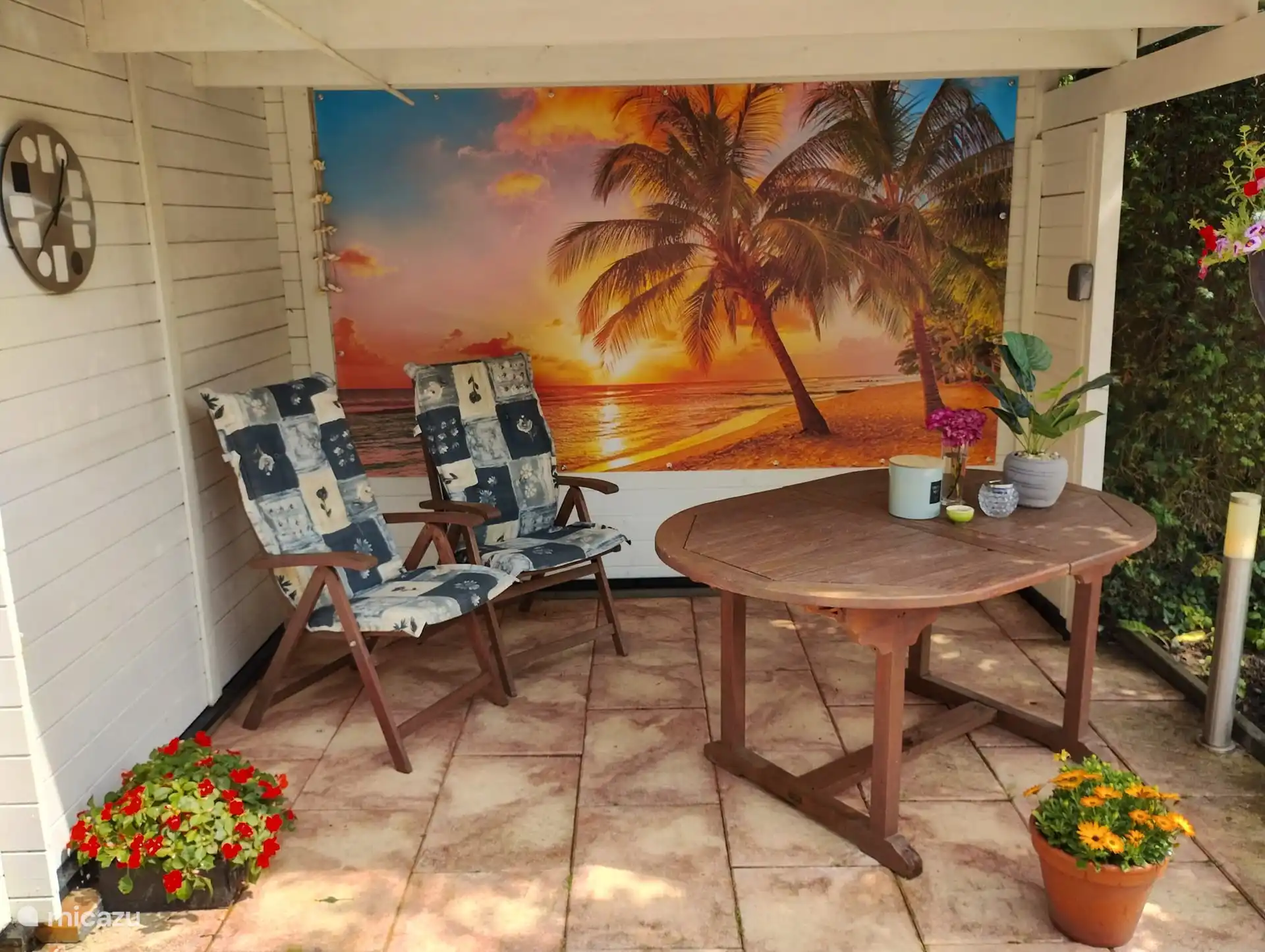 Genießen Sie eine der Terrassen im Garten. Diese Terrasse hat ein Dach, wer sitzt nicht gerne unter Palmen?