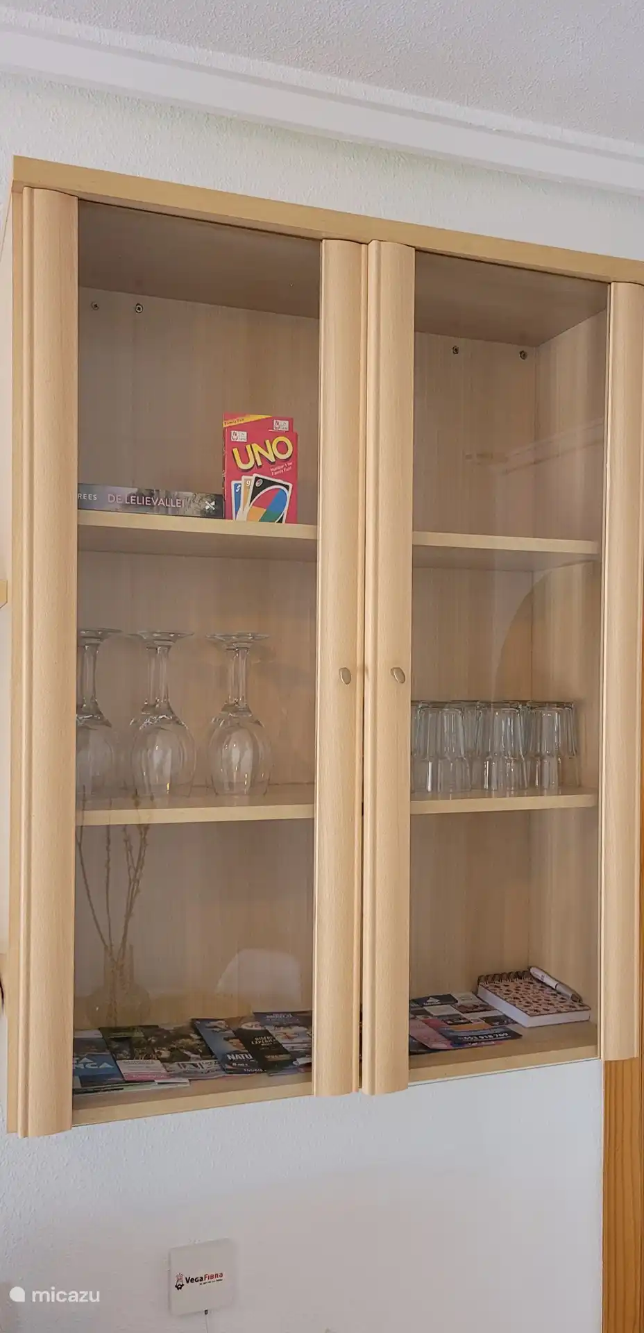 La vitrina está llena de un montón de vasos, un juego y folletos de actividades en Torrevieja y sus alrededores 