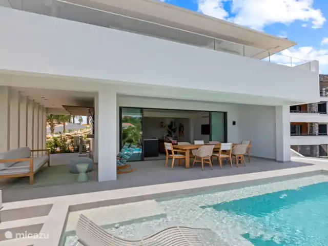 Station balnéaire de Blue Bay | Villa Bocazul 1 | Curaçao, Curaçao-Centre, Blue Bay - villa Terrasse spacieuse avec table à manger, coin salon et piscine
