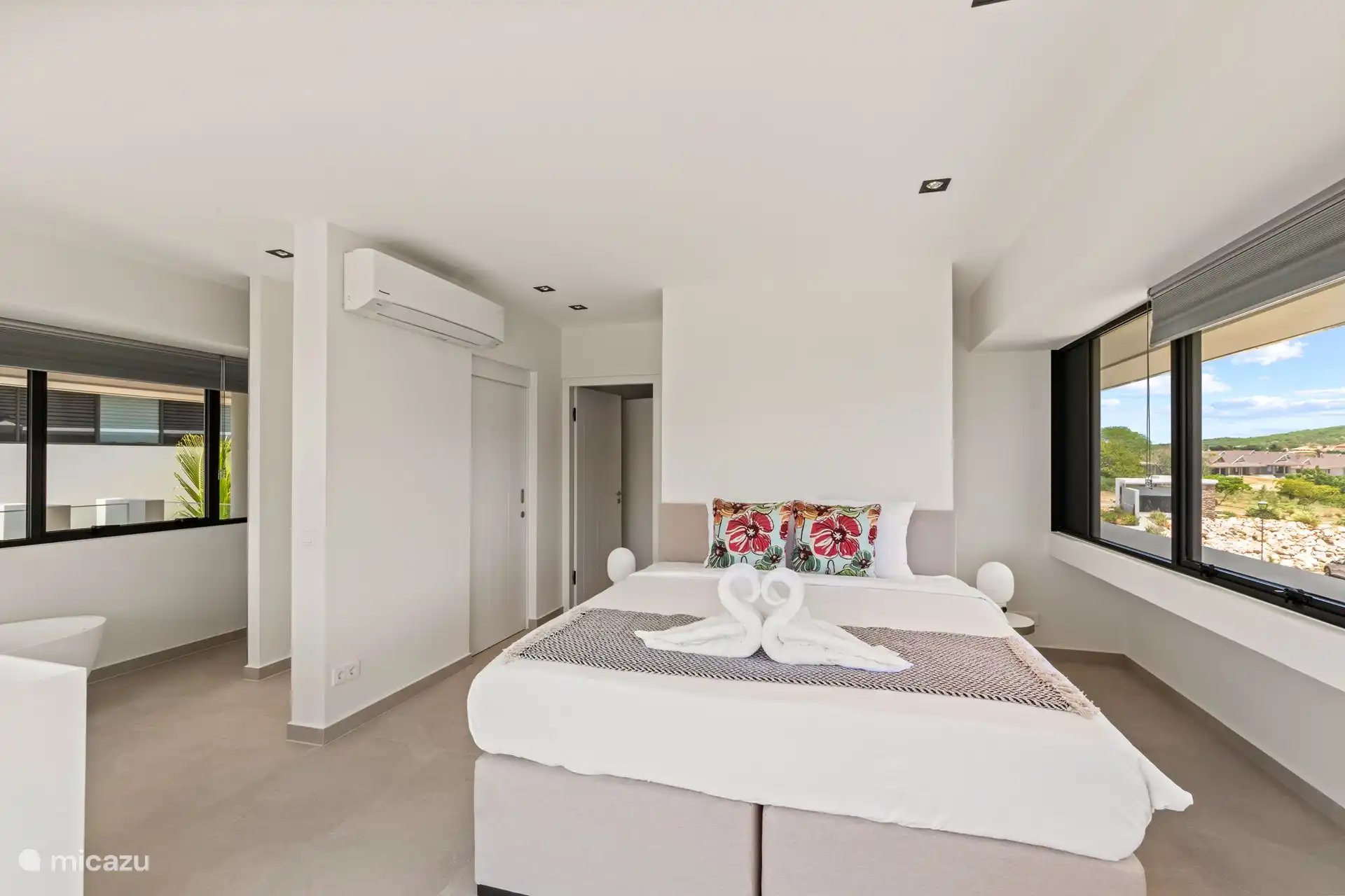 Hauptschlafzimmer mit Doppelbett, Badewanne, Dusche und Klimaanlage