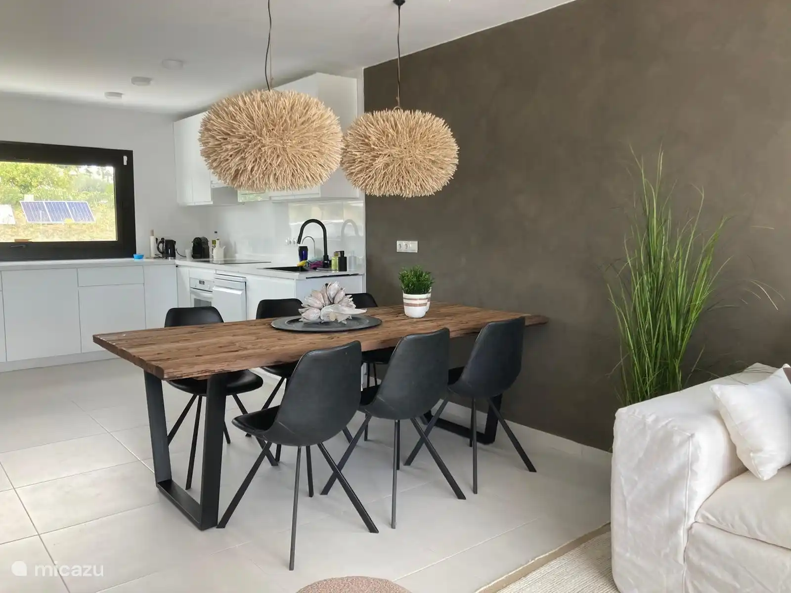 Ansprechend eingerichtetes Wohnzimmer mit offener Küche.