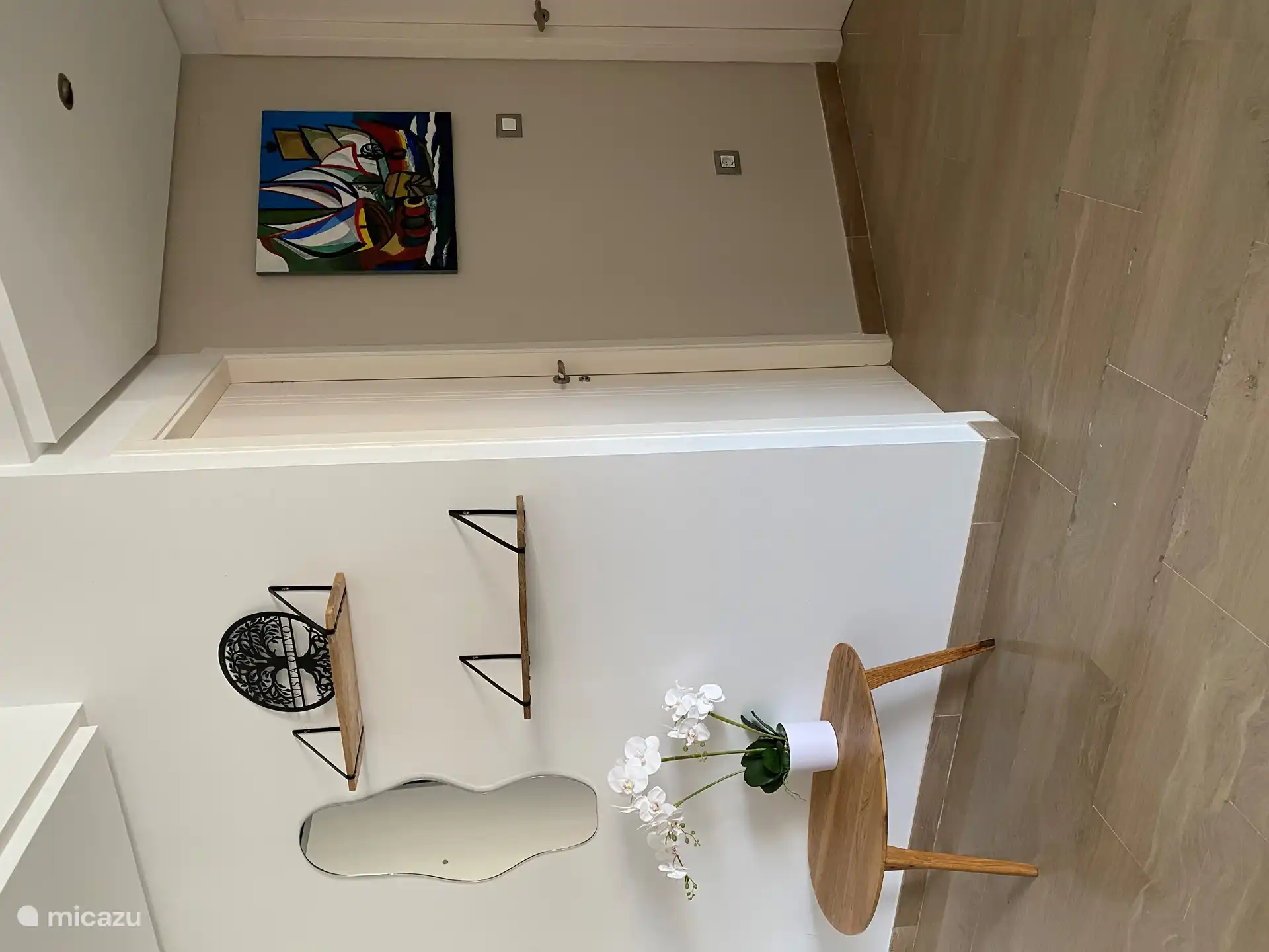 À l’entrée, un mur sépare la salle à manger et vous entrez dans le couloir vers les chambres et les salles de bains ou la cuisine.