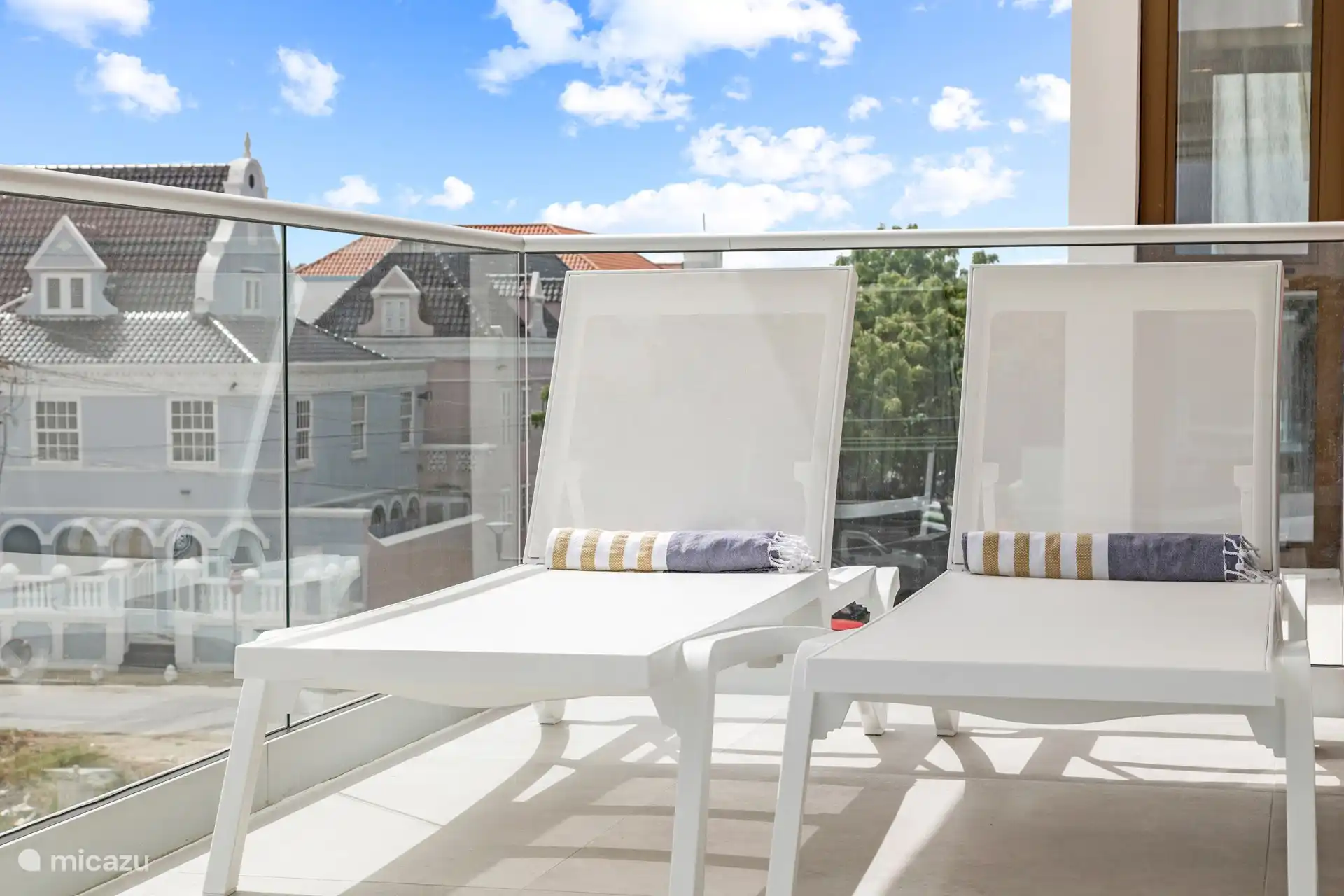 Großzügige, schattige Terrasse mit bequemen Liegen