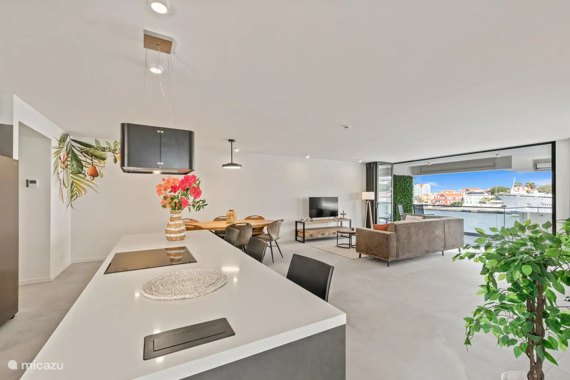 Offene Küche mit Kühlschrank mit Gefrierfach, Induktionsherd, Backofen und Geschirrspüler. 