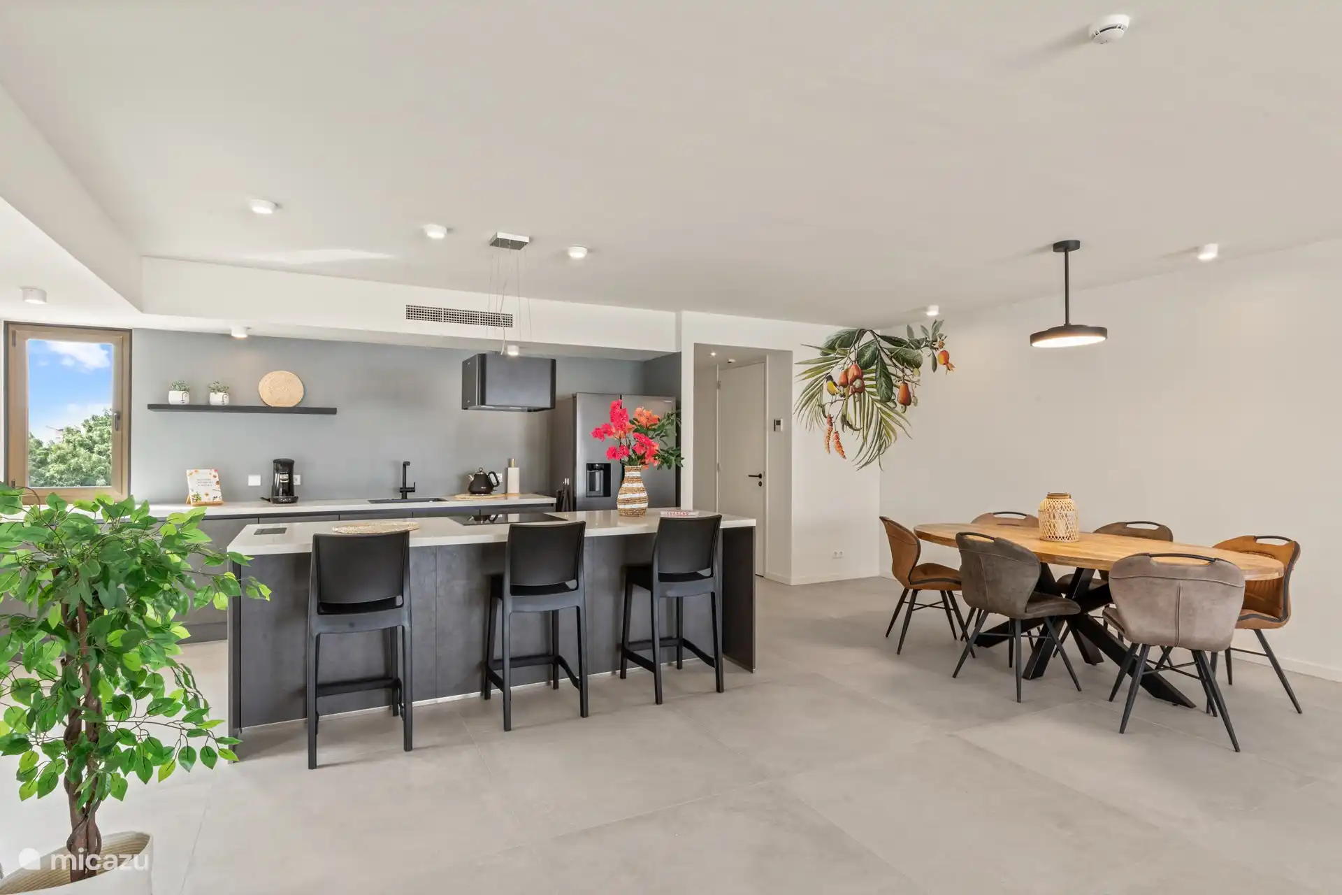 Offene Küche mit Kühlschrank mit Gefrierfach, Induktionsherd, Backofen und Geschirrspüler. 