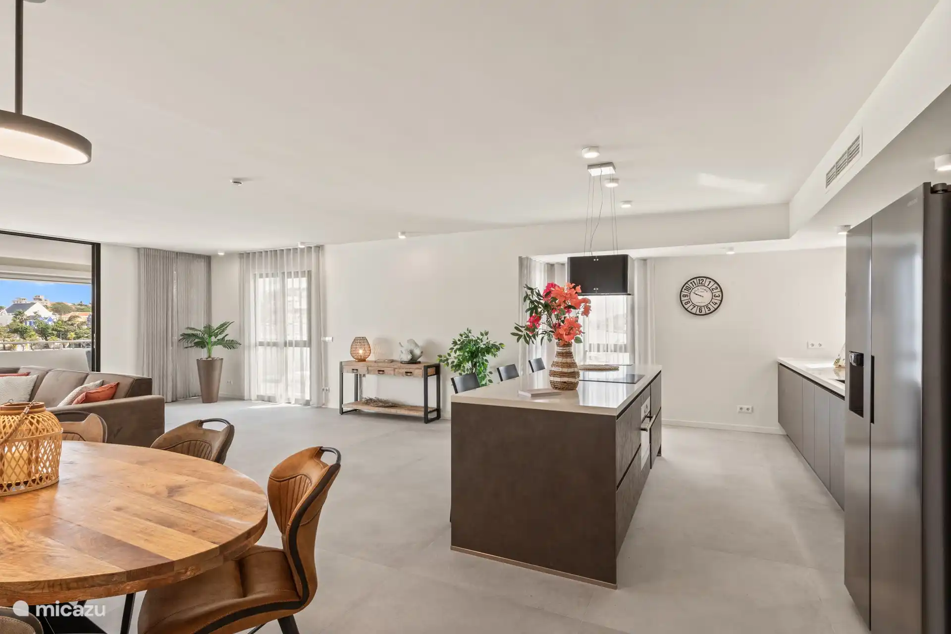 Offene Küche mit Kühlschrank mit Gefrierfach, Induktionsherd, Backofen und Geschirrspüler. 