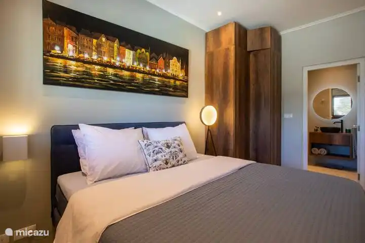 Bedroom with air conditioning and large double bed and smart TV with Bose installation. 