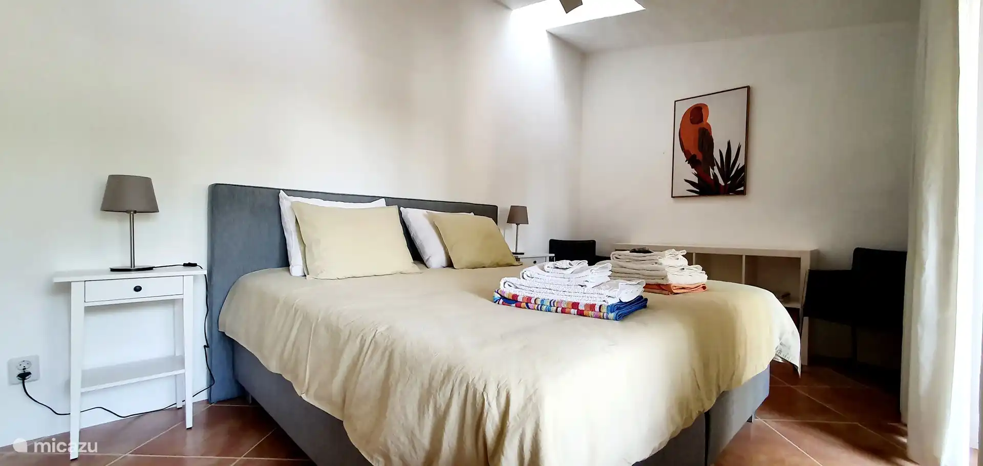 Schlafzimmer im Erdgeschoss mit einer Tür zur Terrasse davor und zum Poolbereich.