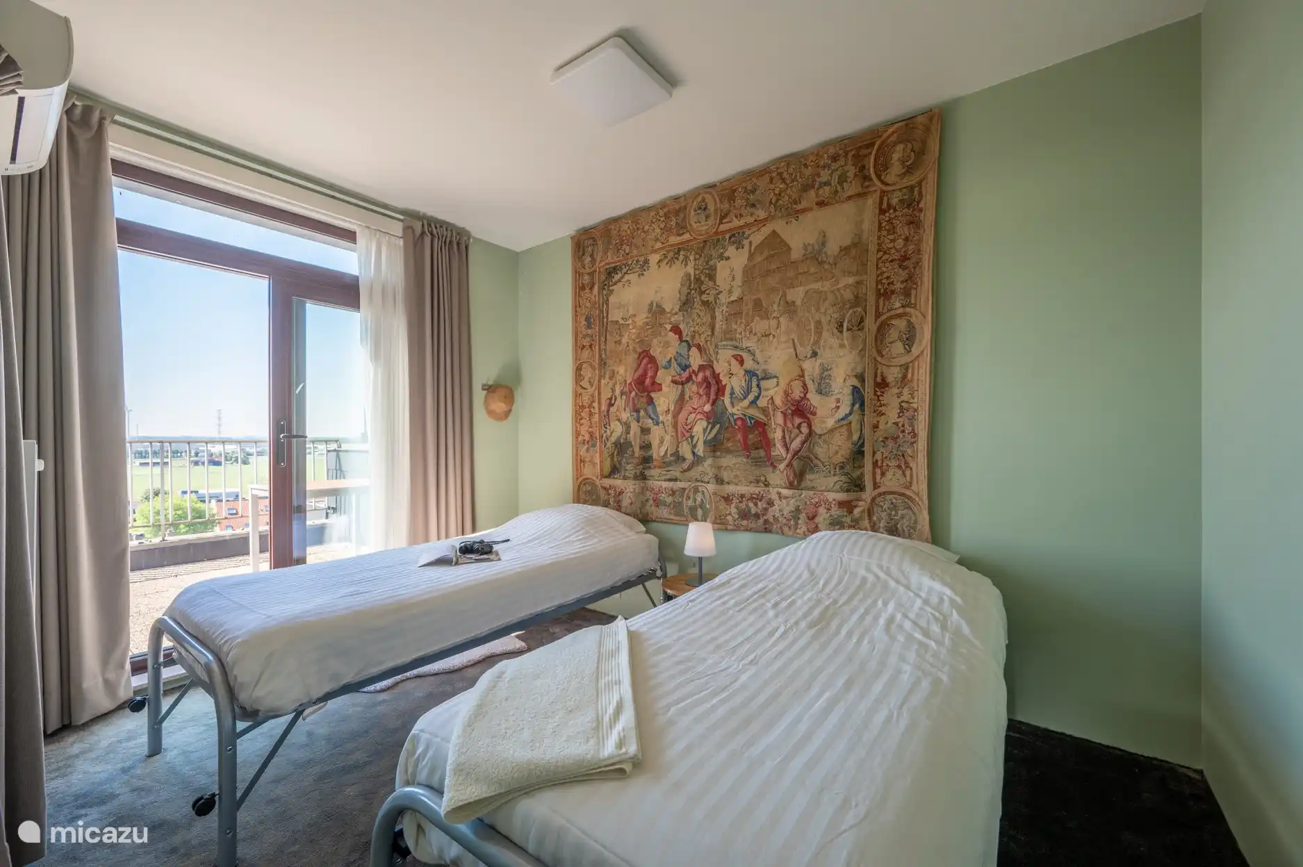 Zicht op de 2de slaapkamer met vasttapijt met 2 separate bedden van 90 x 200 cm.