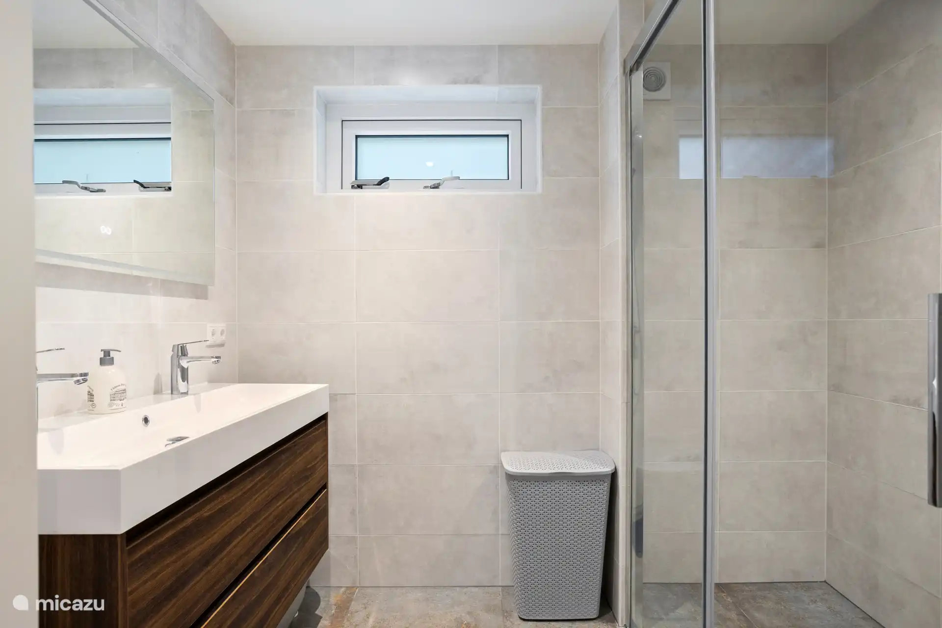 Das Badezimmer im Erdgeschoss verfügt über eine geräumige, begehbare Regendusche und ein Doppelwaschbecken.