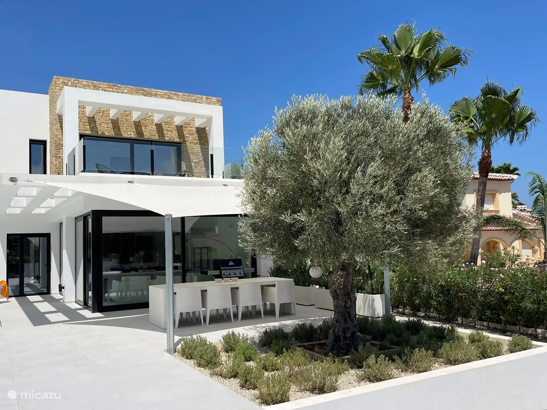 Grande table d’extérieur avec chaises et auvent d’ombrage. Grand BBQ au gaz. 
