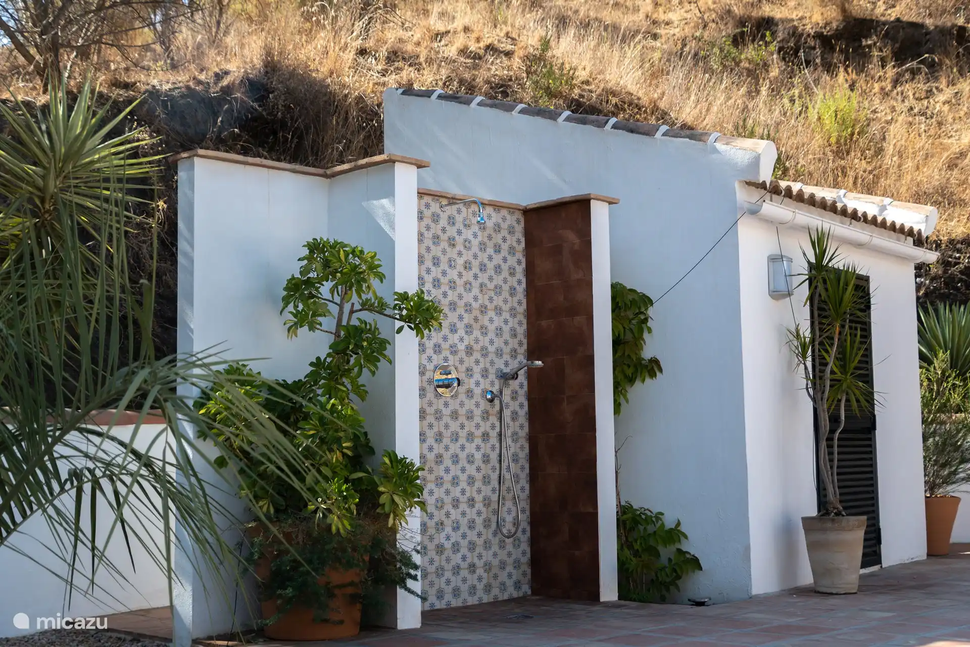 Une douche extérieure pour se rafraîchir et rincer les huiles et lotions avant d’entrer dans la piscine. 