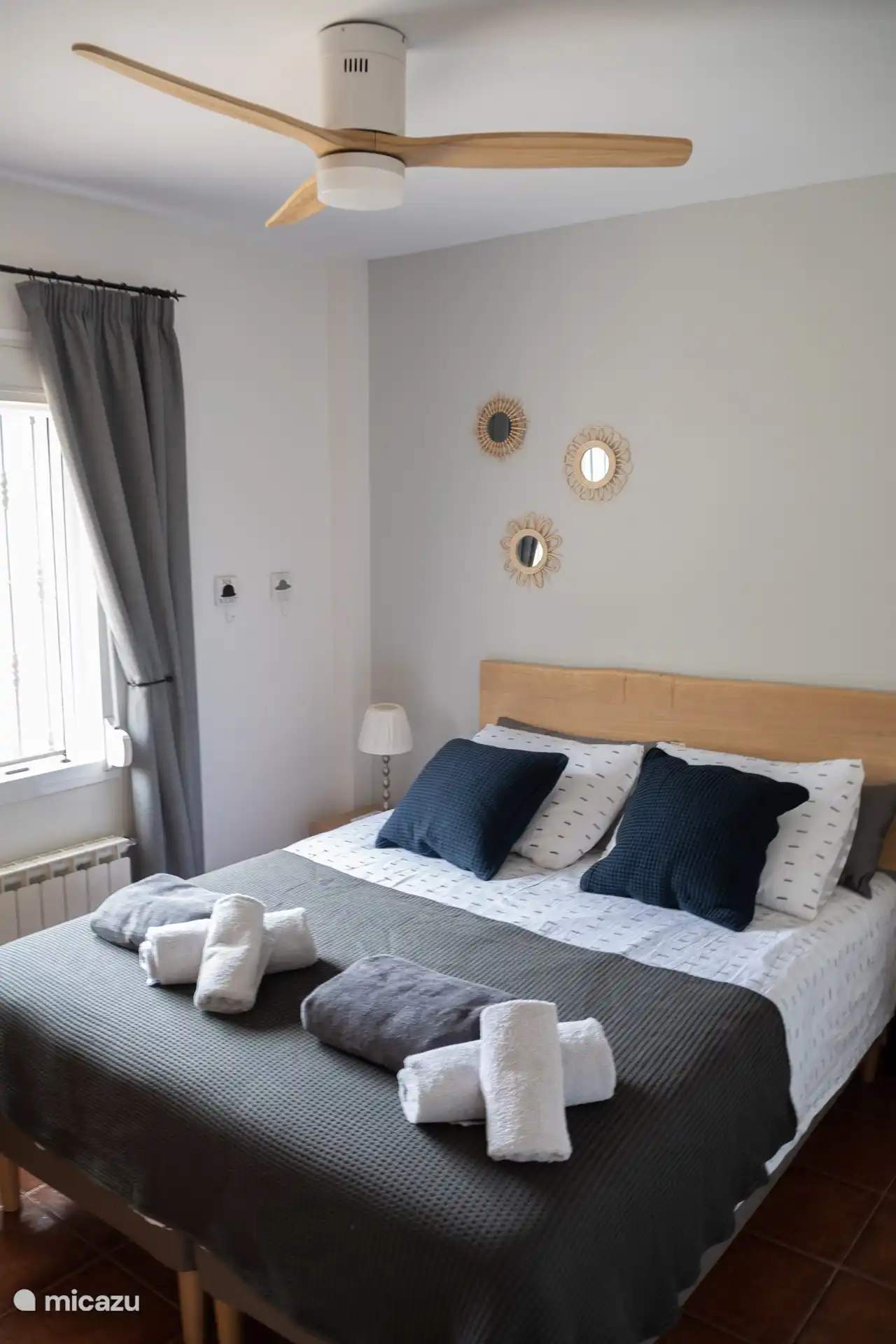 La chambre 2 avec vue dispose d’un lit king size, d’armoires encastrées et d’un ventilateur de plafond. 