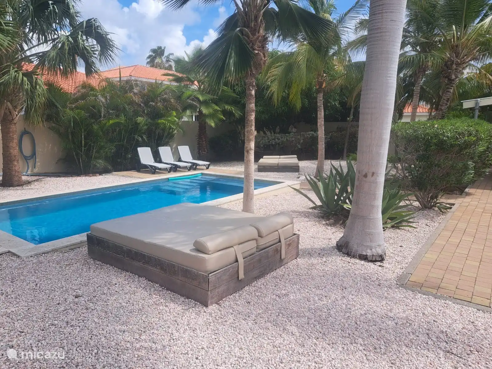 Zwembad met ligbedden en lichstoelen