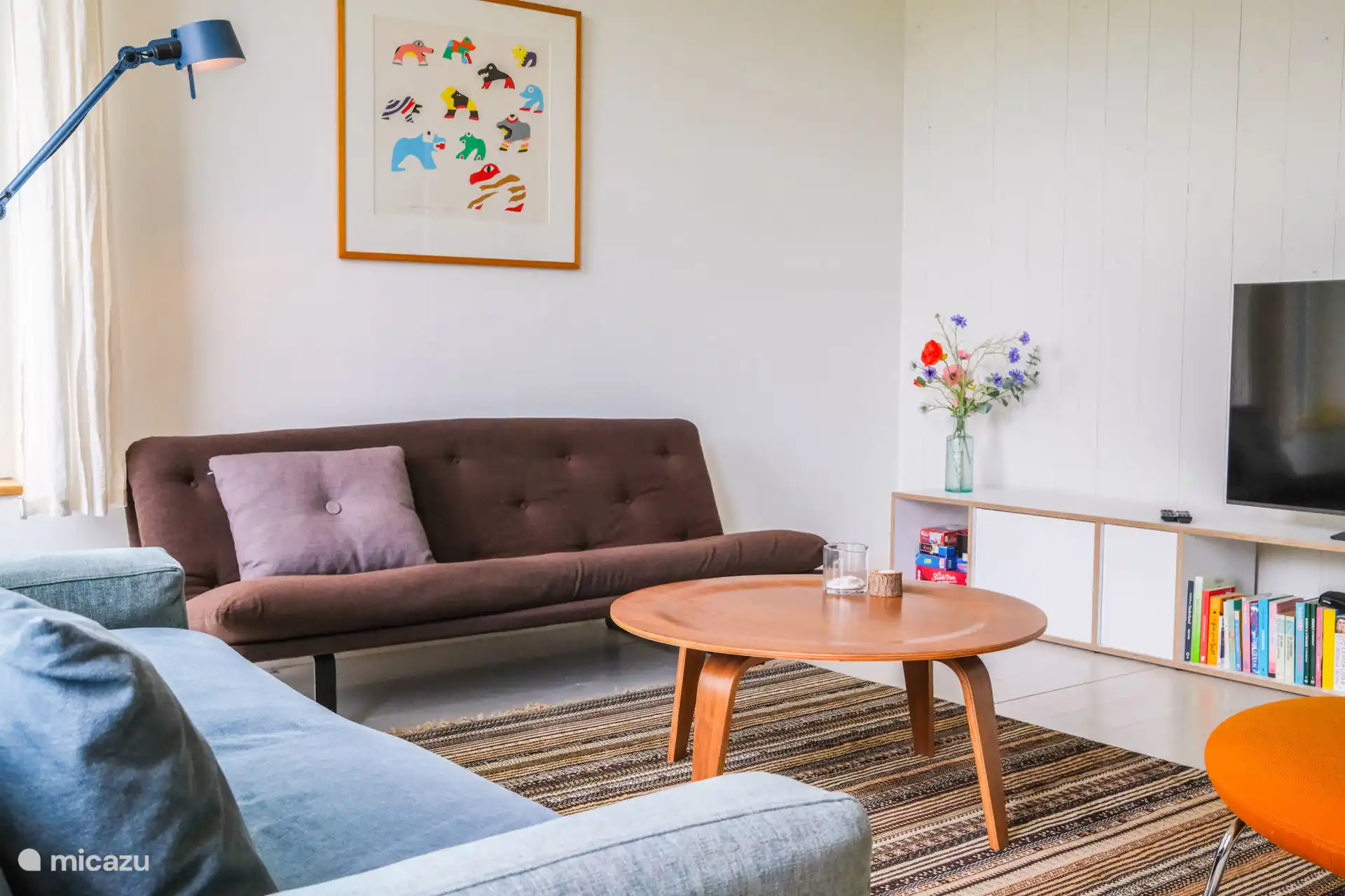 Das Wohnzimmer mit 2 Sofas, großem Fernseher und Boxbett