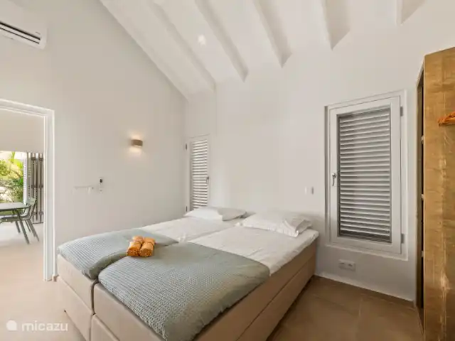 Villa Blenchi Curaçao Zwembad & Tuin huren in Curaçao, Curacao-Midden, Willemstad - vakantiehuis Lichte slaapkamer met twee losse Eastborn boxsprings (2,10 m), opgemaakt als eenpersoonsbedden. Voorzien van airco, plafondventilator en een eigen badkamer met regendouche