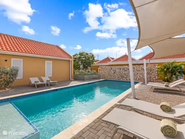 Villa Blenchi Curaçao Zwembad & Tuin huren in Curaçao, Curacao-Midden, Willemstad - vakantiehuis Het royale zoutwaterzwembad van 10 bij 4 meter vormt het hart van Villa Grandi. Omgeven door een tropische tuin en comfortabele ligbedden van Fermob is dit de perfecte plek om te ontspannen