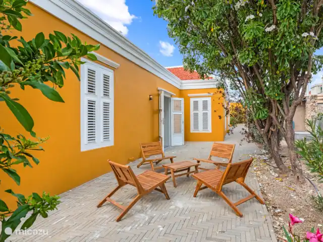 Stadsvilla Curaçao, Zwembad & Tuin huren in Curaçao, Curacao-Midden, Willemstad - vakantiehuis Charmant zijterras met sfeervolle zitplek onder de tropische bomen, ideaal voor ontspannen momenten in de luwte van de stad