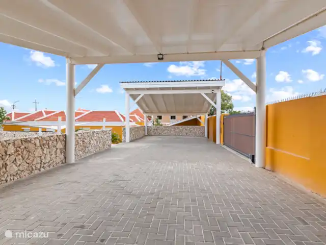Stadsvilla Curaçao, Zwembad & Tuin huren in Curaçao, Curacao-Midden, Willemstad - vakantiehuis Ruime carport op het afgesloten terrein, toegankelijk via een elektrisch bedienbare rolpoort – veilig en comfortabel parkeren binnen de muren van het resort