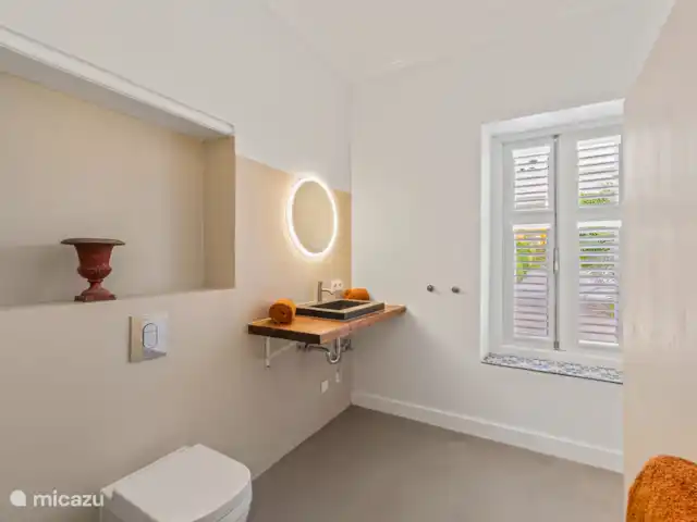 Resort privé Curaçao pour les groupes | Curaçao, Curaçao-Centre, Willemstad - villa Salle de bain lumineuse avec lavabo en pierre naturelle, éclairage design et vue sur le jardin tropical