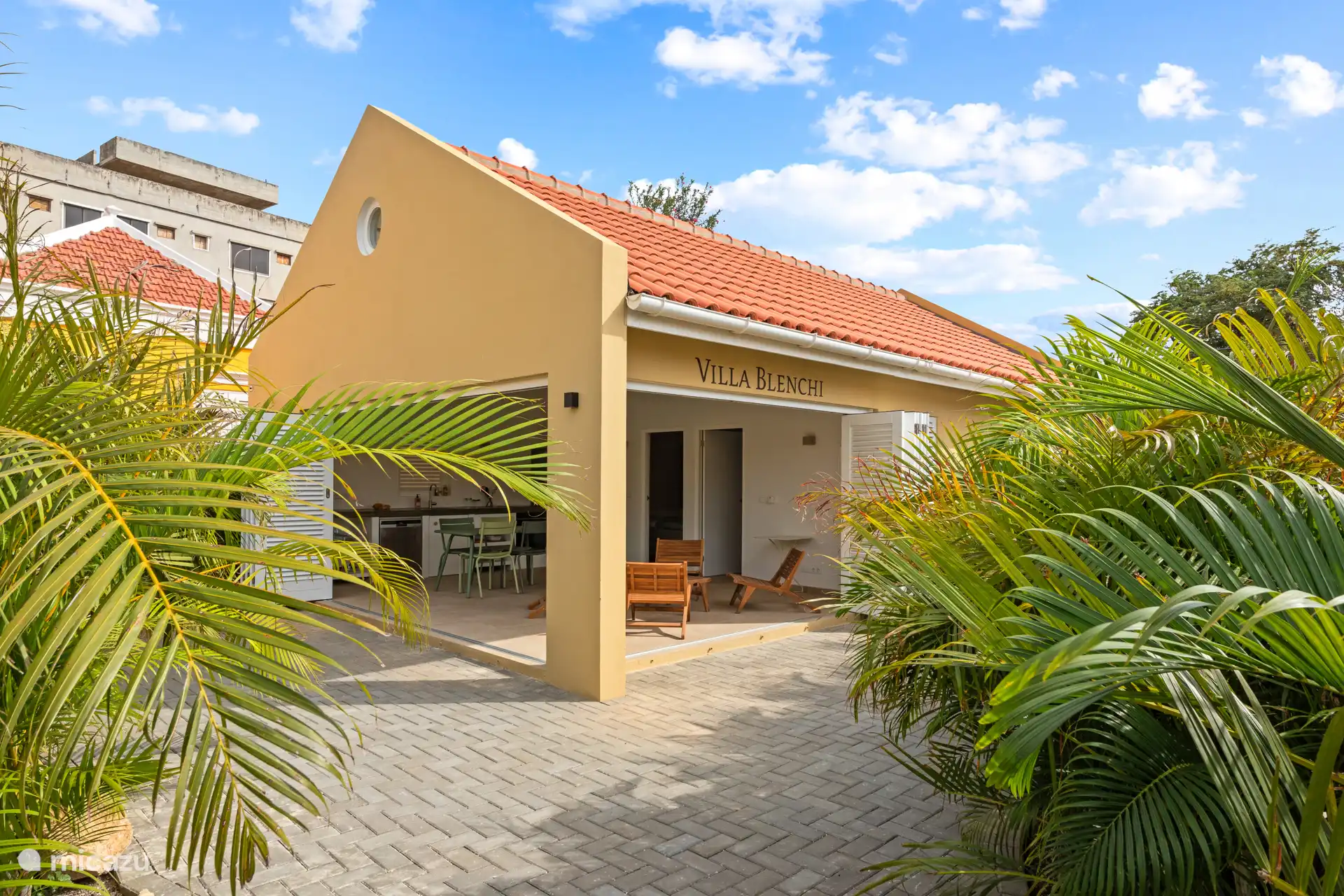 Villa Blenchi with shutter folding doors, open kitchen and spacious terraces bordered by greenery. Indoors and outdoors flow effortlessly into each other – ideal for relaxed outdoor living