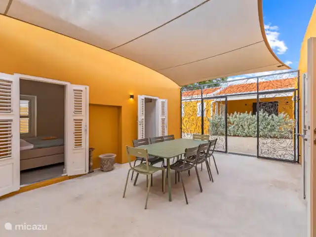 Resort privé Curaçao pour les groupes | Curaçao, Curaçao-Centre, Willemstad - villa Cour attrayante avec un élégant portail d’entrée en fer forgé, un pare-soleil et une table à manger spacieuse - un endroit intime pour profiter de l’extérieur