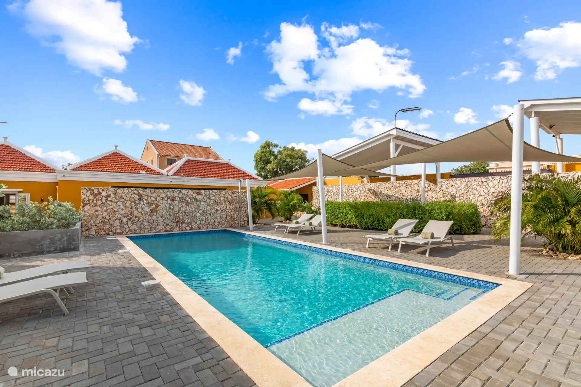 The spacious saltwater swimming pool of 10 by 4 meters forms the heart of Villa Grandi. Surrounded by a tropical garden and comfortable Fermob sunbeds, this is the perfect place to relax