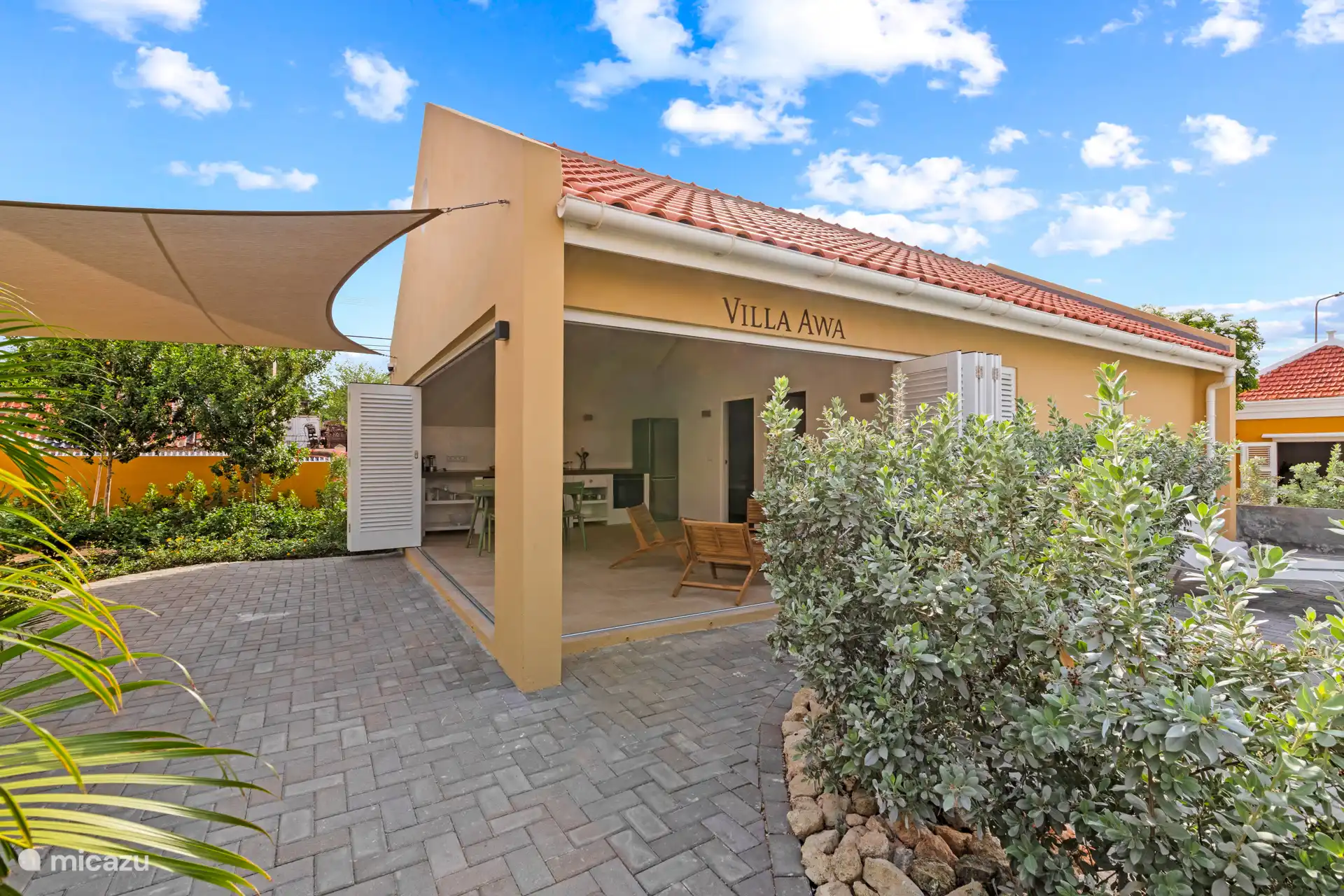 Villa Awa with shutter folding doors, open kitchen and spacious terrace with sun cloth. Indoors and outdoors flow effortlessly into each other – ideal for relaxed outdoor living