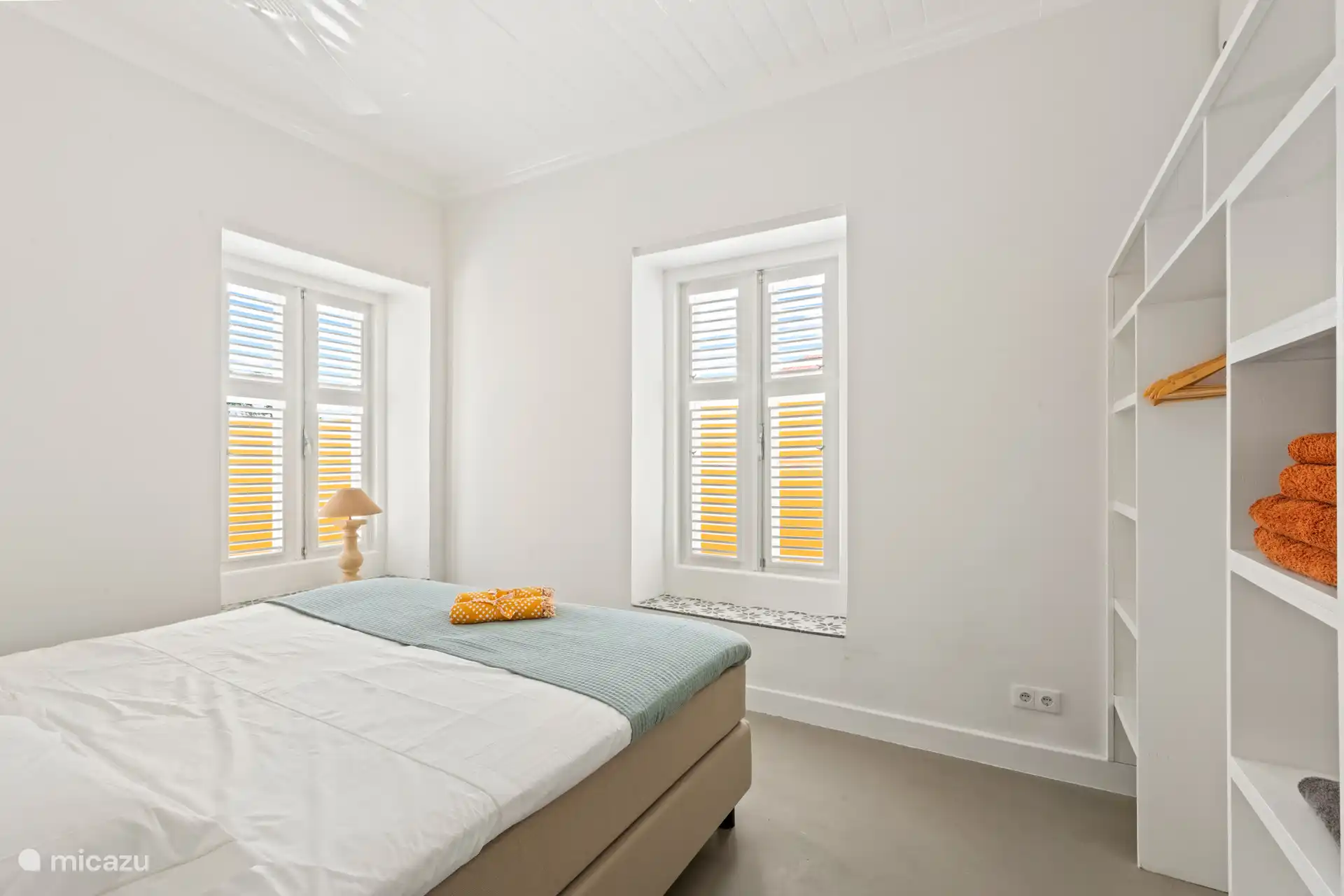 Bright room with air conditioning, open closet and two single box springs, joined together to form a comfortable double bed