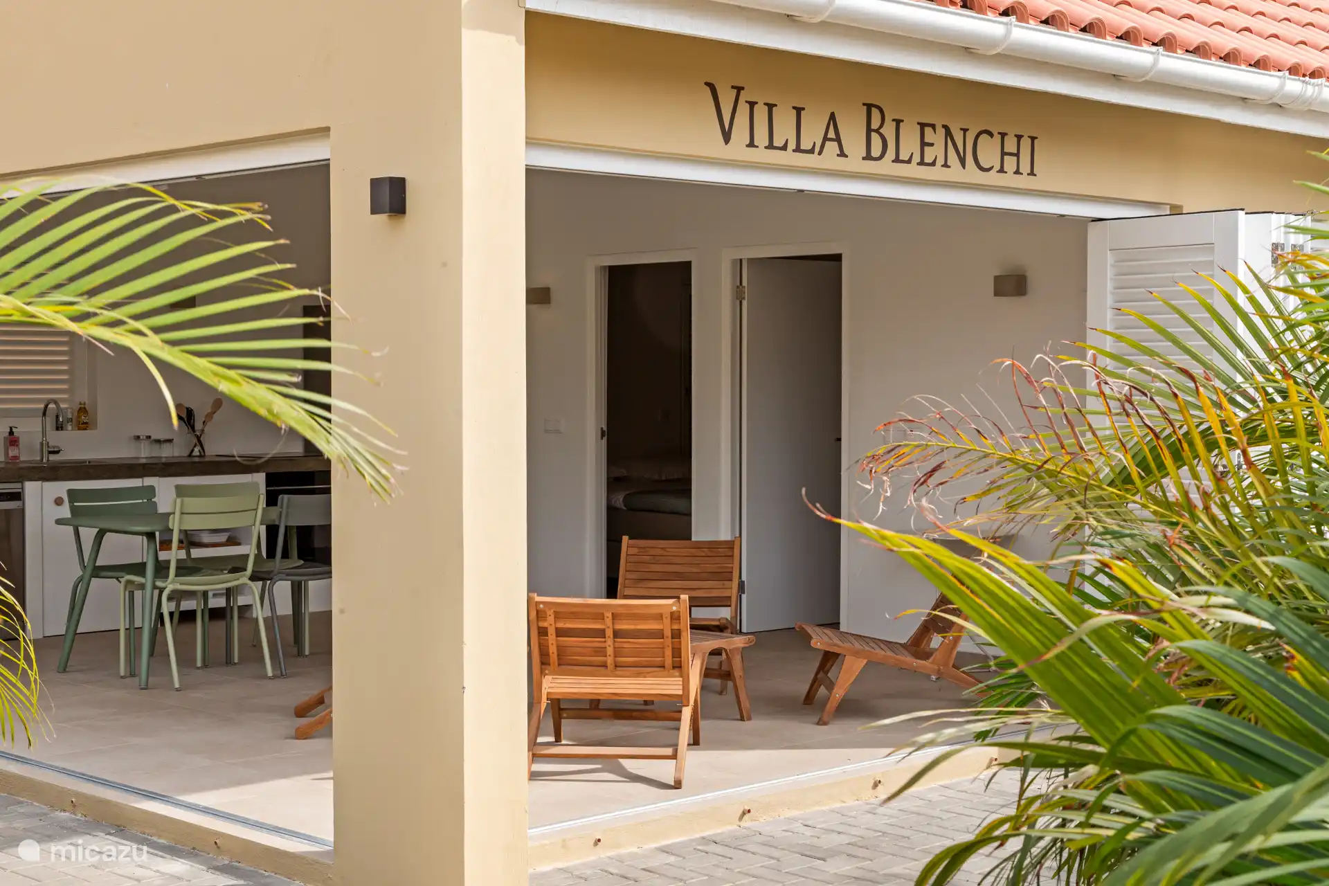 Villa Blenchi with shutter folding doors, open kitchen and spacious terraces bordered by greenery. Indoors and outdoors flow effortlessly into each other – ideal for relaxed outdoor living