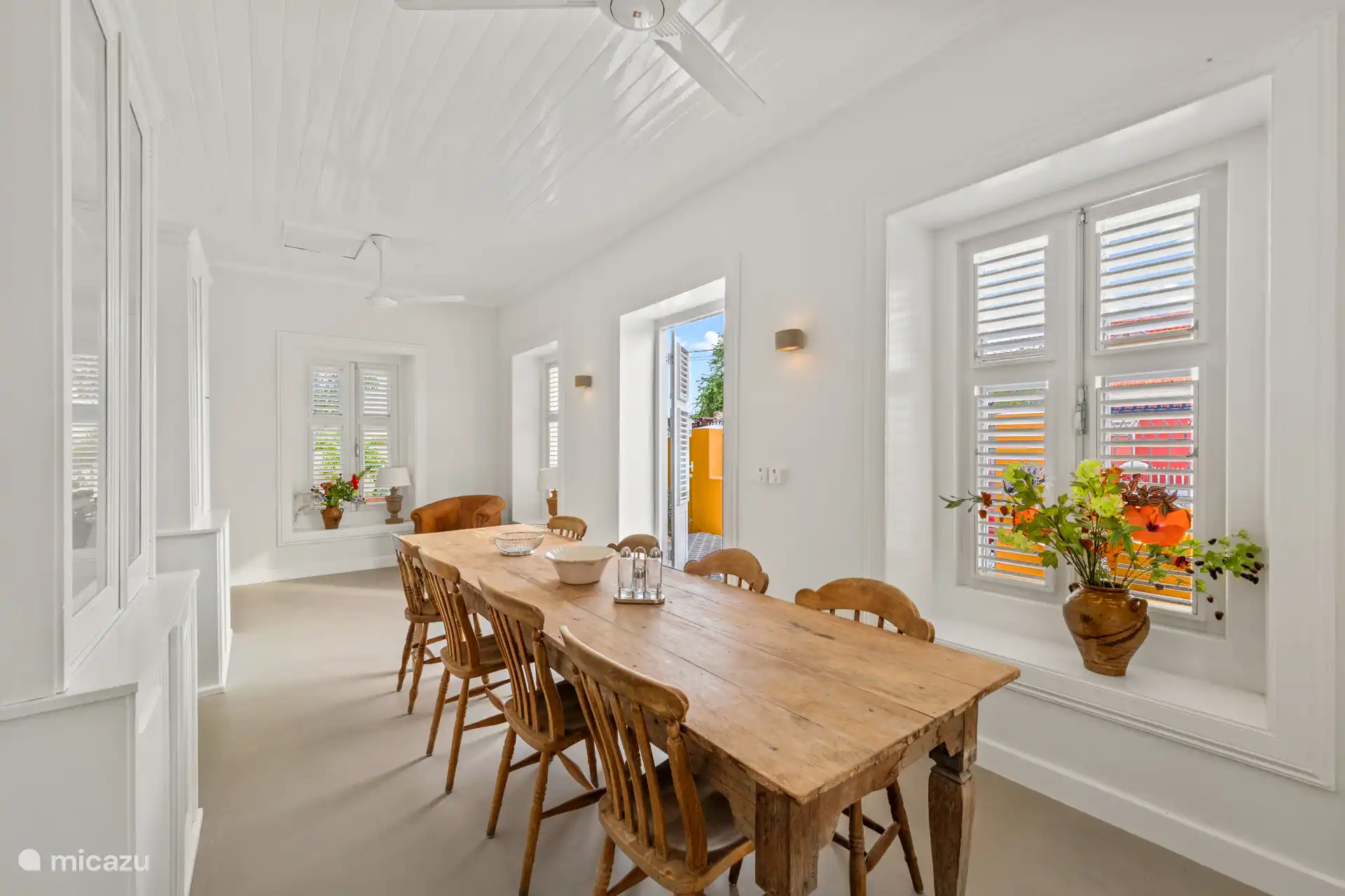 Authentic dining room with elegant wooden table, high ceilings and characteristic shutter shutters – a special setting for atmospheric dining
