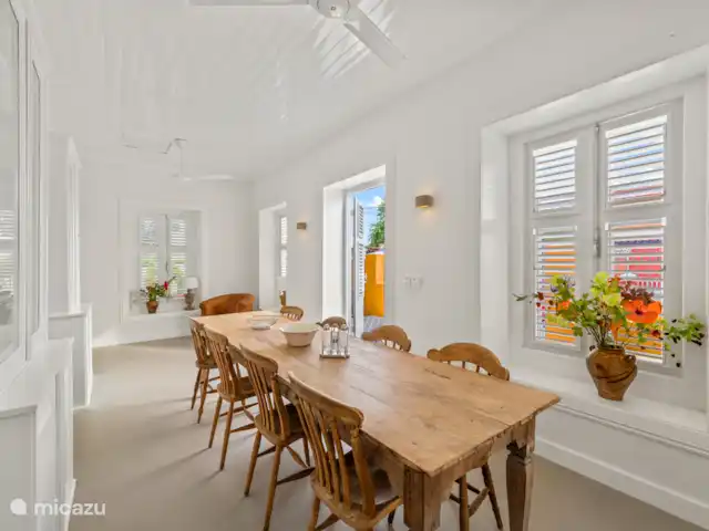 Resort privé Curaçao pour les groupes | Curaçao, Curaçao-Centre, Willemstad - villa Salle à manger authentique avec une élégante table en bois, de hauts plafonds et des volets caractéristiques - un cadre particulier pour un dîner d’ambiance