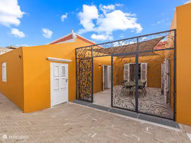 Resort privé Curaçao pour les groupes | Curaçao, Curaçao-Centre, Willemstad - villa Cour attrayante avec un élégant portail d’entrée en fer forgé, un pare-soleil et une table à manger spacieuse - un endroit intime pour profiter de l’extérieur