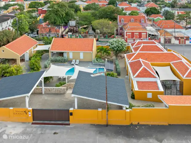 Resort privé Curaçao pour les groupes | Curaçao, Curaçao-Centre, Willemstad - villa Vue arrière de la Villa Grandi avec un grand parking, un joli jardin de cour, une piscine d’eau salée et une villa de ville monumentale au cœur d’Otrobanda