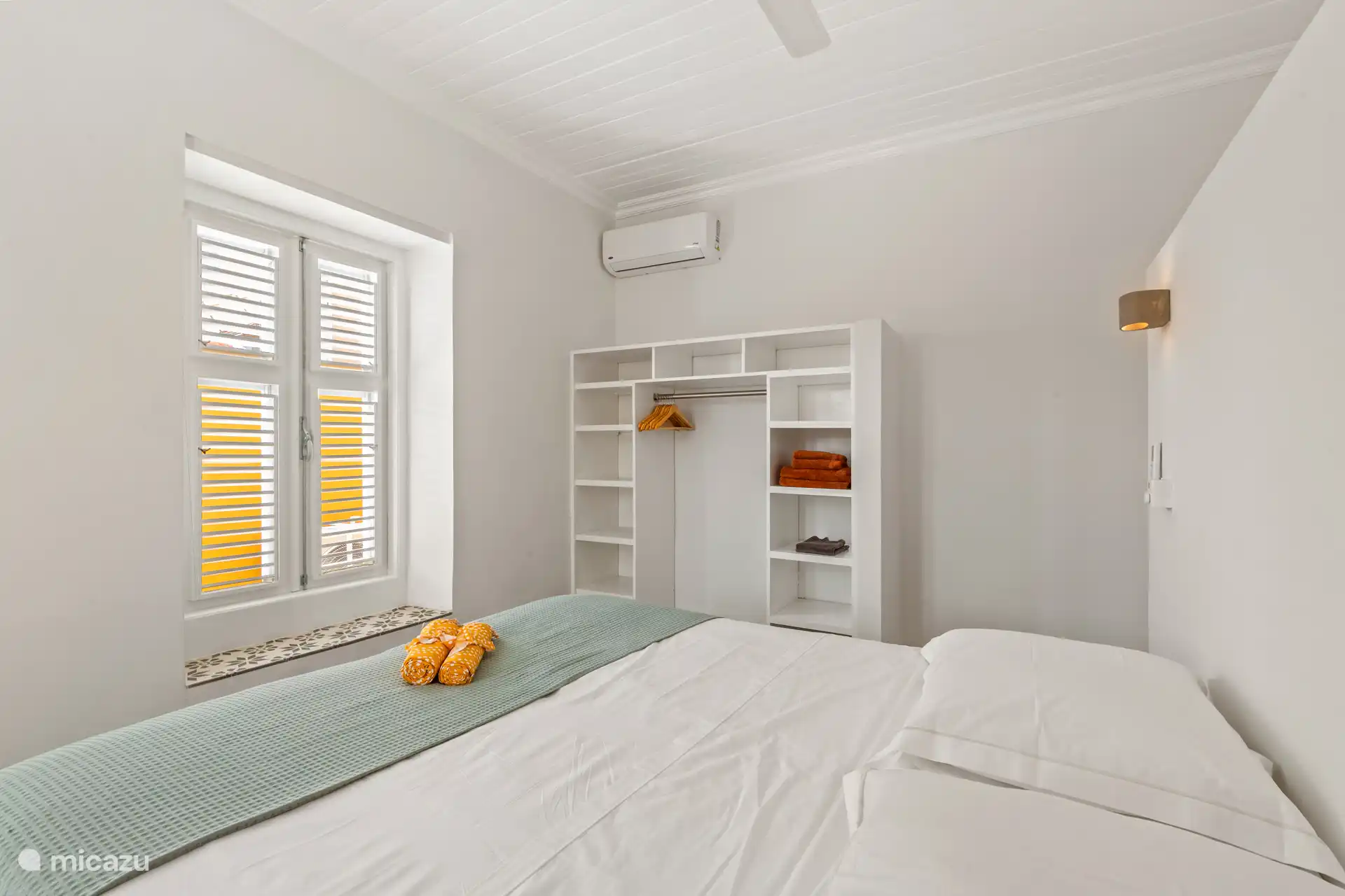 Comfortable room with air conditioning, ceiling fan and generous storage cupboard – ideal for two