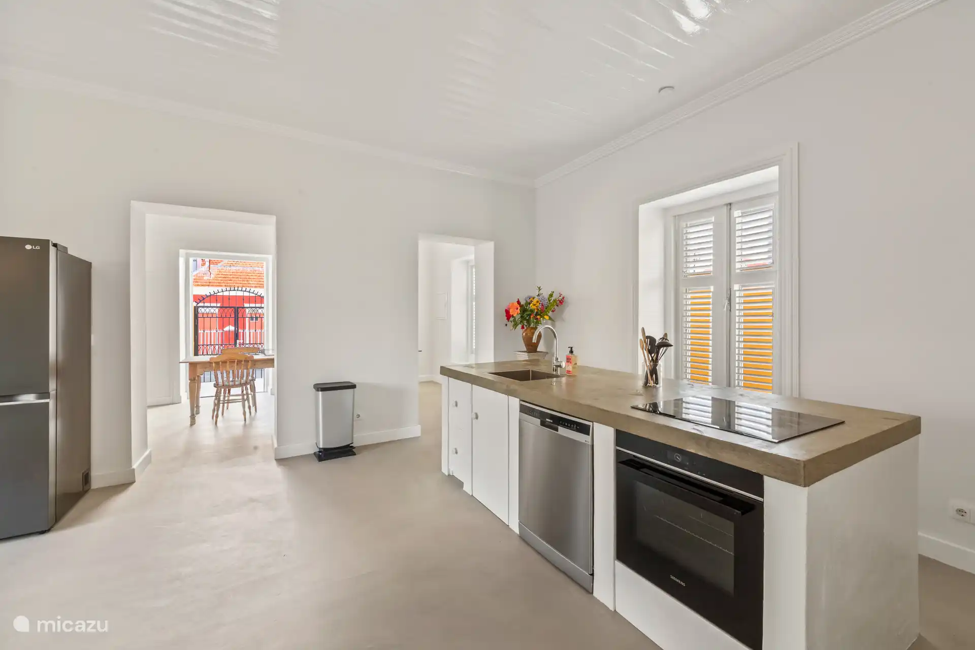 Bright kitchen with modern worktop, stylish sitting area and open connection to the attractive dining room