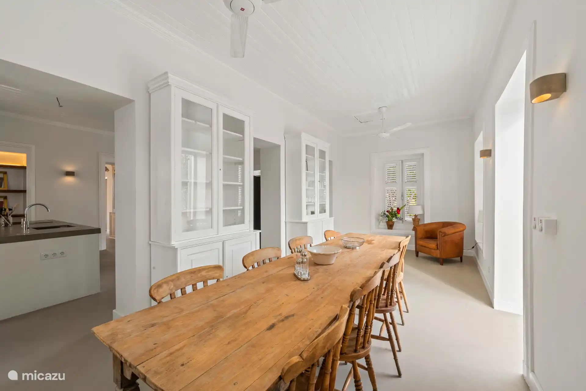 Authentic dining room with elegant wooden table, high ceilings and characteristic shutter shutters – a special setting for atmospheric dining