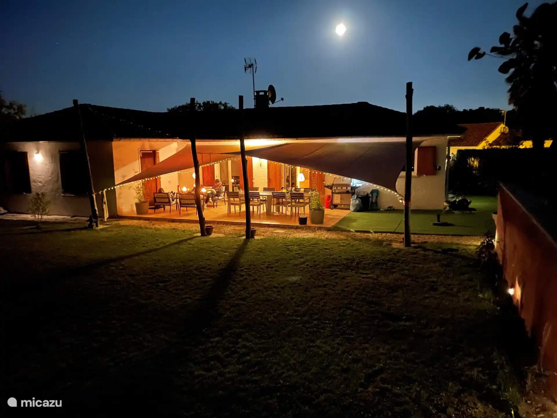 Rückseite des Hauses mit (überdachter) Terrasse und Tisch im Freien für 8 Personen