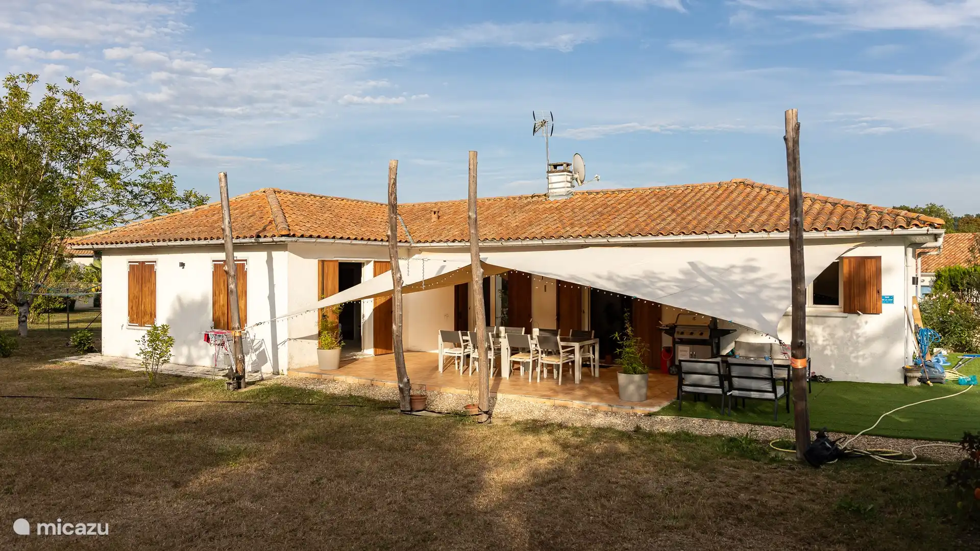 Rückseite des Hauses mit großer (überdachter) Terrasse und Tisch im Freien für 8 Personen