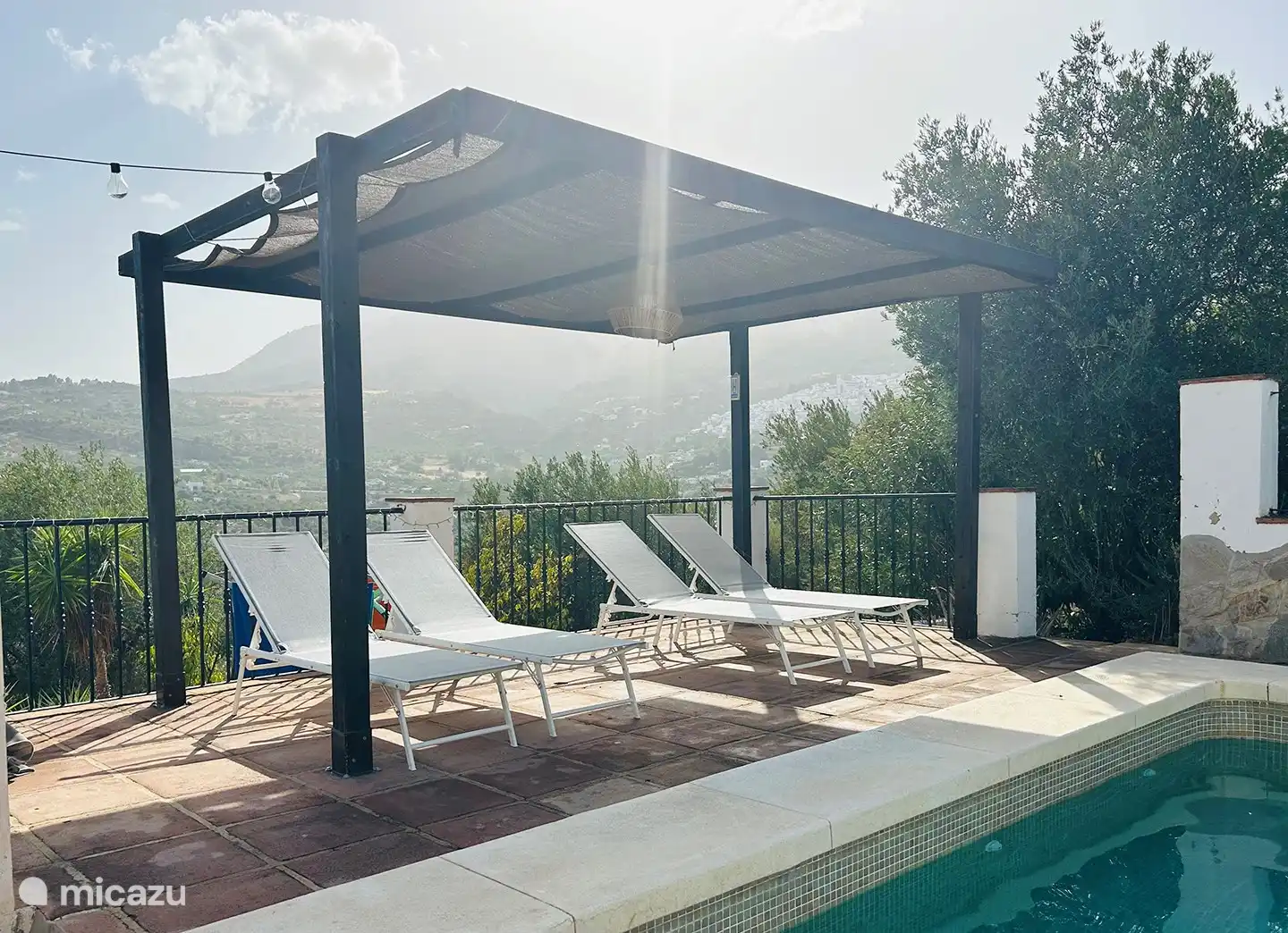 Terraza solárium con una hermosa vista del valle por un lado y del típico pueblo español de montaña blanca de Casarabonela por el otro. 