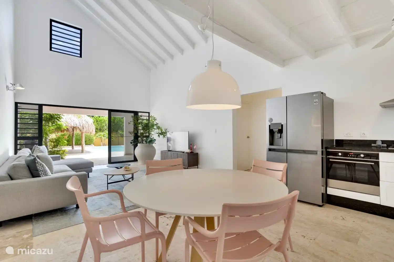 The living room is spacious, with high ceilings and an L-shaped open kitchen 