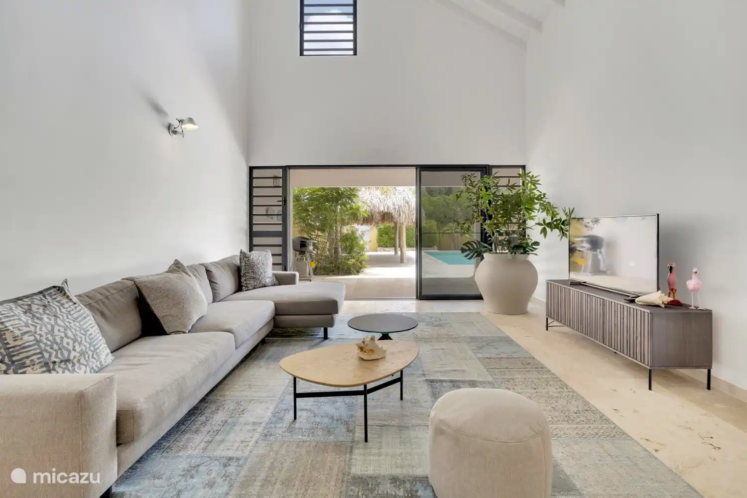 The living area is spacious, with high ceilings and an L-shaped open-plan kitchen equipped with high-quality European appliances. 