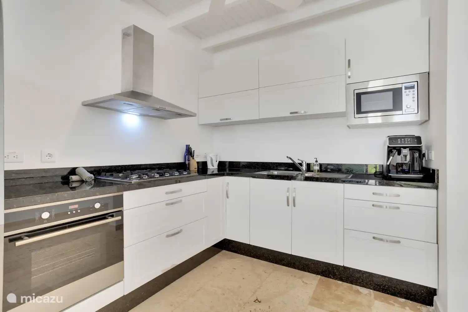 L-shaped open kitchen that is equipped with high-quality European appliances. 