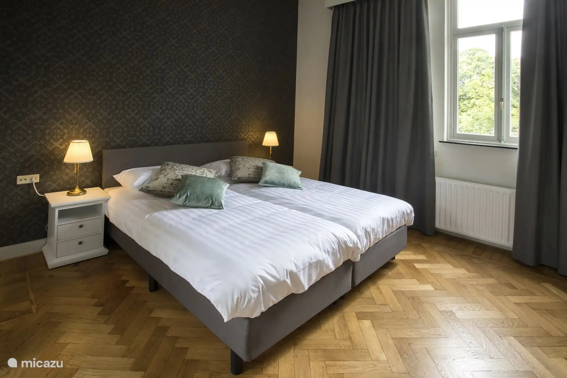 Dieses Schlafzimmer verfügt über eine eigene Dusche mit Waschbecken, eine gemütliche Sitzecke, einen Kleiderschrank und den Fernseher