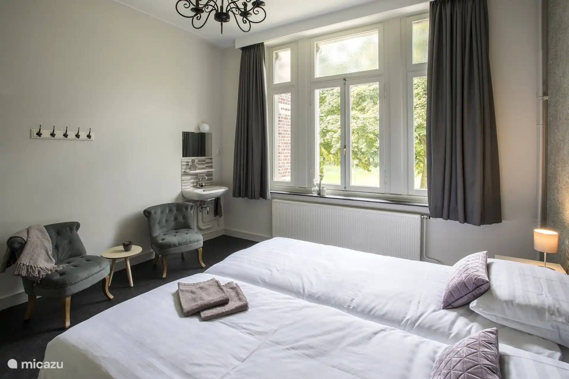 Schlafzimmer mit Waschbecken, gemütlicher Sitzecke und TV