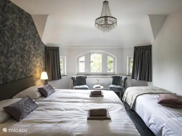 Villa Venray | Pays-Bas, Limbourg, Venray - villa Cette chambre dispose de trois lits à sommier tapissier, d’un lavabo, d’un coin salon, d’une armoire intégrée.